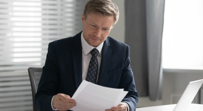 Business executive reading CAPE denial letter