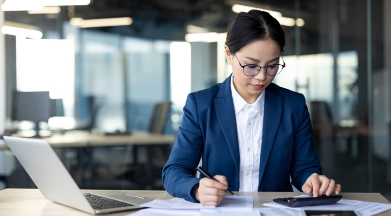 Asian business professional working on accounting documents